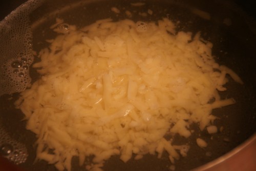 First handful. Whisk as little as possible to melt to avoid breaking the cheese.