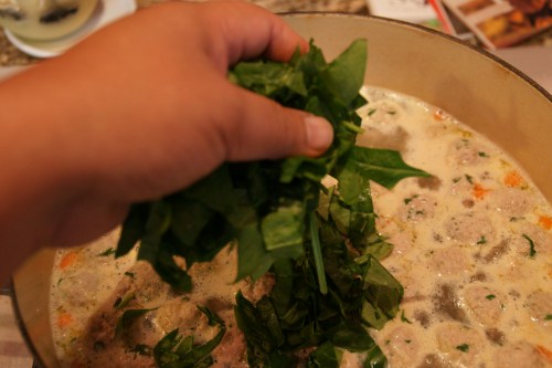 Add by the handfuls, not all at once to maintain the simmer for the pasta.