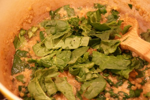 Add spinach by the handful, stirring til wilted