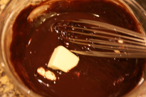 Add the next piece of butter when the first one is almost completely incorporated into the chocolate